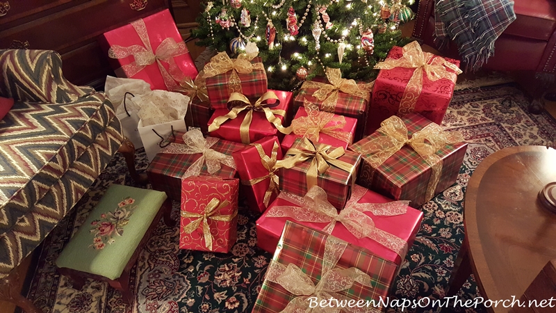 Christmas presents wrapped in green and red plaid paper with gold ribbon